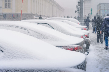 snow covered cars in parking lot during winter season