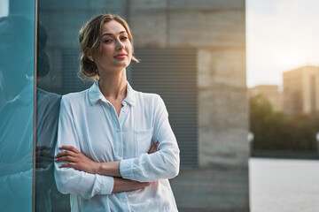 Businesswoman successful woman business person standing arms crossed outdoor corporate building exterior. Smile happy caucasian confidence professional business woman middle age