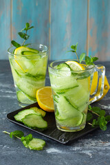 Fresh Cold and refreshing detox water with lemon and cucumber on a stone table. Copy space.