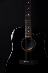 Black acoustic guitar studio shot on black background with copyspace, Guitar is favorite music instrument for hobby.