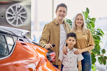 Beautiful caucasian family happy to get keys from their new car, they spent a lot of time choosing...