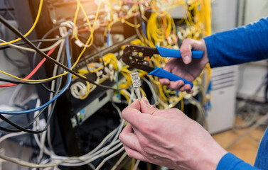 Network engineer working in server room. Connecting network cables to switches