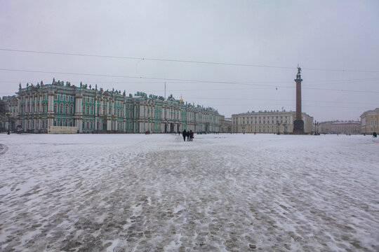 Saint Petersburg / Russia - February 18, 2017:  State Hermitage Museum and Palace square in winter which is full snow cover but tourists are still visiting the palace in the winter.