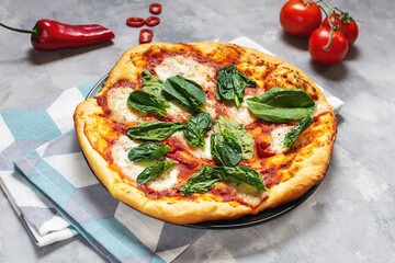 Homemade pizza margarita with mozzarella, tomatoes and basil on concrete background