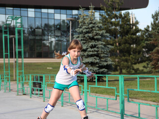 A girl rollerblading in the Park. The child is engaged in sports. Asset in the fresh air. Children...