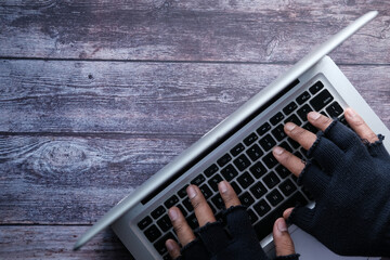 Fototapeta premium hacker hand stealing data from laptop top down 