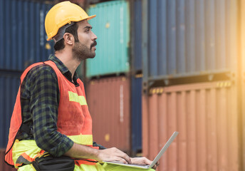 Foreman using laptop to check containers