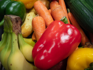 Diverse Obst und Gemüsesorten mit einer Paprikaschote im Vordergrund