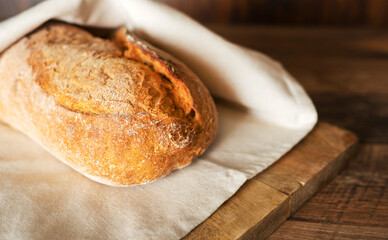 Freshly baked bread wrapped in a towel.