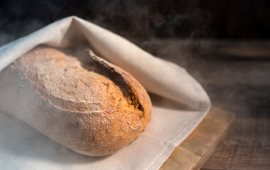 Freshly baked bread wrapped in a towel.