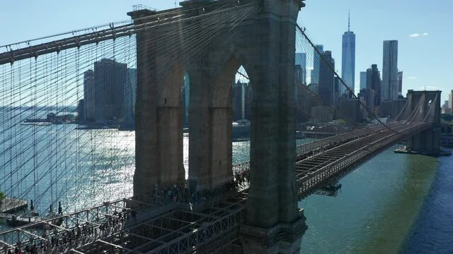 flying backward view of BLM marchers walking across Brooklyn Bridge towards NYC