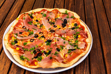 Tasty hot italian pizza with ham, mushrooms and olives.  Traditional Italian food. Concept poster for Restaurants or pizzerias.