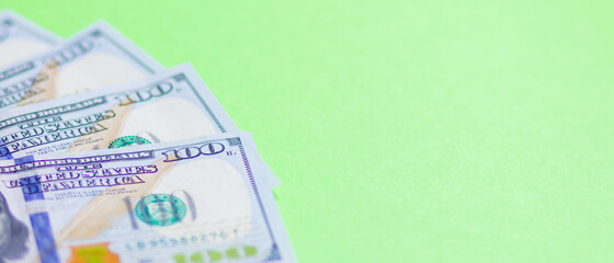 One hundred dollars on a green background. American currency. Conceptual background of hundred dollar bills for design. Copy space