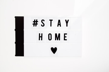 White lightbox inviting people to stay at home and protect themselves from pandemia, on a white background top view flatlay