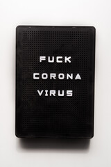Fuck corona virus, graphic image, black lightbox,rebellion against covid-19 pandemic, resilience against coronavirus crisis concept, flatlay composition, on a white background,