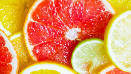 Fototapeta na wymiar Beautiful background with pieces of ripe cut citrus fruits