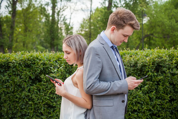 Naklejka na ściany i meble Boy and girl using smartphone outdoor