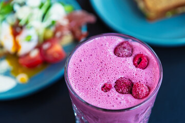Breakfast meal & raspberry smoothie drink in glass.Detox diet & healthy nutrtion in vegetarian cafe...