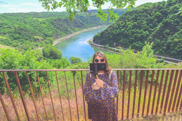 Beautiful mountain landscape with young woman enjoying wanderfull view, taking a good selfie