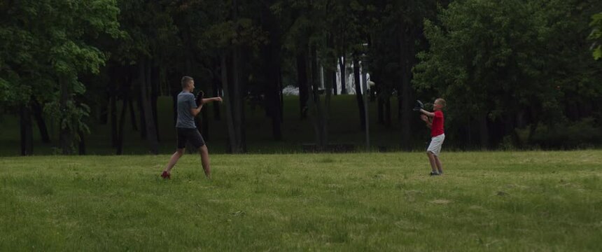 WIDE Two brothers or friends playing baseball catch in the park. Family time spent together. Shot with 2x Anamorphic lens