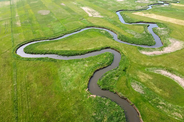 Aerial view landscape of winding river in green field.