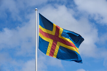 The flag of Åland against a blue sky.   