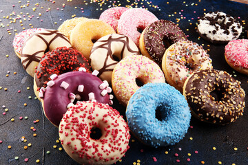 assorted donuts with chocolate frosted, pink glazed and sprinkles donuts