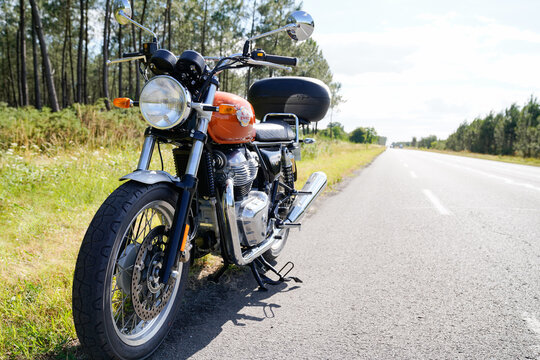 Royal Enfield motorcycle orange color parked in side road with vintage indian motorbike