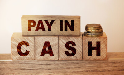 Pay in cash text on wooden cubes text and coins. Payment methods business concept