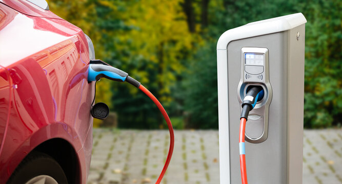 Close-up Of An Electric Car With A Cable Connected And A Charging Station