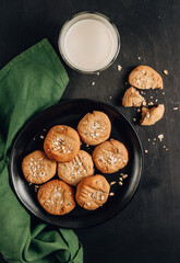 Gluten free homemade oatmeal cookies and oat milk on a dark background.