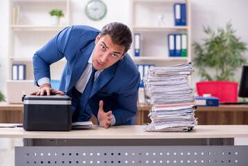 Young male employee making copies at copying machine