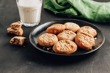 Gluten free homemade oatmeal cookies and oat milk on a dark background.