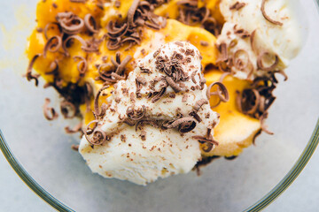 vanilla ice cream with chocolate chips in bowl, yellow ice cream with mango, peach