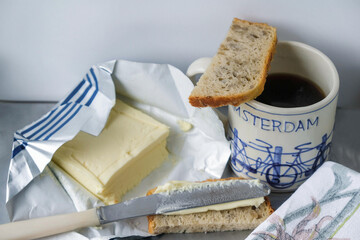  Still life with a piece of sunflower bread, coffee and butter in gray-blue color in the morning in Ukraine.