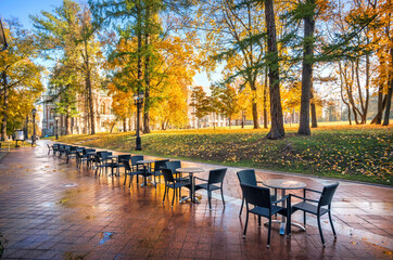 Fototapeta na wymiar Tsaritsyno Palace and empty cafe tables in autumn landscape