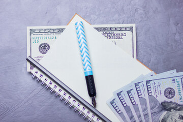 Financier workplace. One hundred dollars. American currency. Notebook and hundred dollar bills on a gray background. Financial investment. Copy space