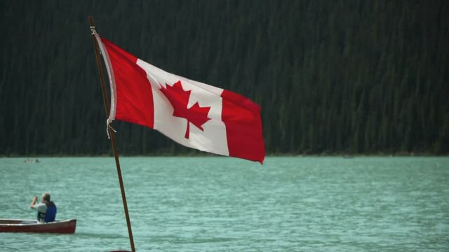 Canadian flag and canoeists on Lake Louise, Banff Alberta