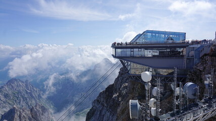 Viewing platform in the Alps with glass architecture. In the front you can see the radio station with antenna mast and satellite system. Zugspitze, mountain in Germany, highest peak.