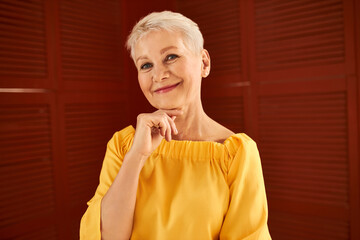Aging, beauty and style concept. Close up image of charming joyful middle aged Caucasian woman with...