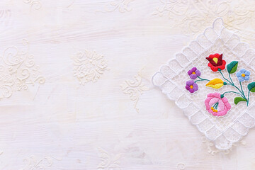 top view of floral tablecloth with over white wooden background
