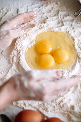 Cooking dough. Chicken eggs in flour on the kitchen table, ingredients. Preparation for baking, culinary recipes. 