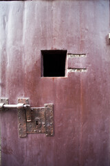 Old rusty door with lock and hole