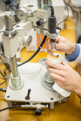A dental technician makes partial dentures on a mechanized machine. The production of the false jaw or dental bridges using the apparatus. Close-up.