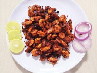 Closeup view of fresh crispy Indian prawn (Fenneropenaeus indicus) fry in white plate.
