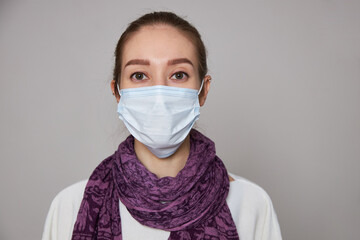 Girl in medical mask on white background empty space