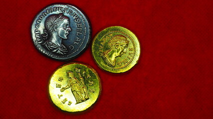 Silver and gold roman coins on red background