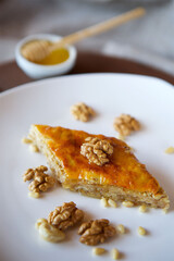 Close-up dessert is a piece of cake with walnuts, honey and pine nuts.