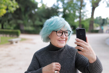 mujer mayor haciéndose un selfie al aire liber
