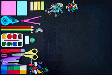 Set of varied colorful school stationary on black chalkboard background. Copy space. Back to school Education concept 